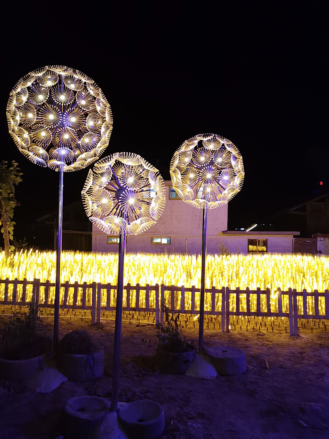 三组球形蒲公英造型灯夜景,可见放射状花头、立杆与下方配重外观;中山市瀚沃灯饰有限公司产品图片资料